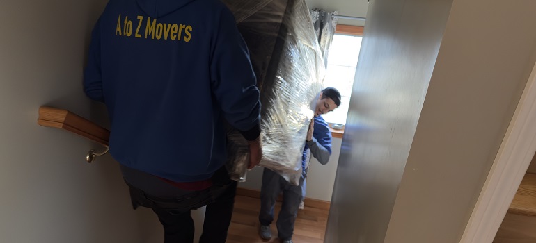 two webster movers carrying a large moving box