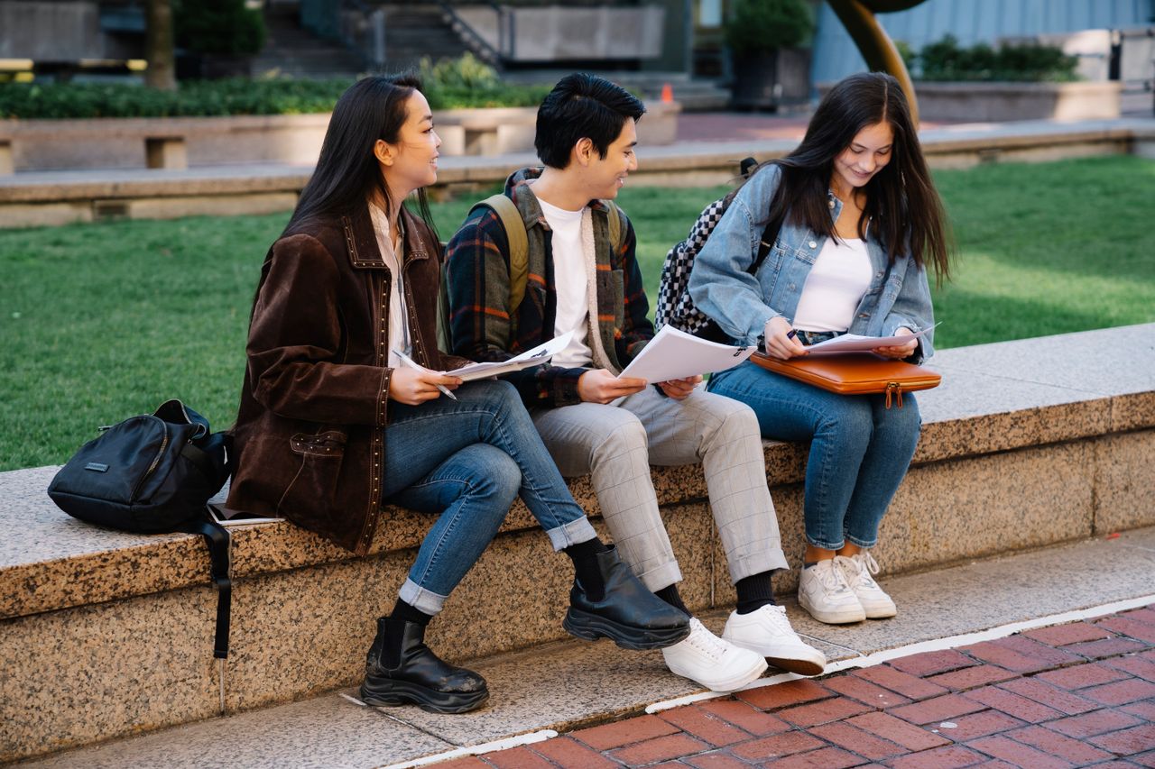 Students sitting on a bench outside and talking