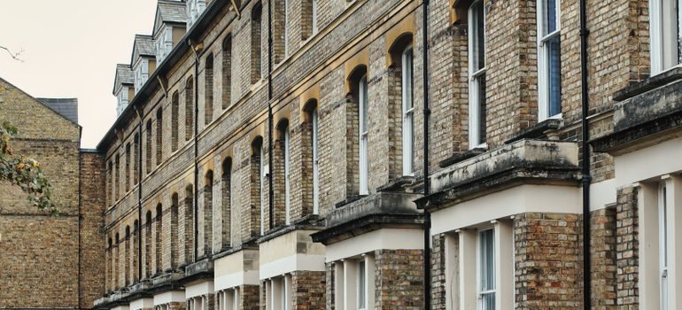 A row of uniform brick Victorian-era townhouses
