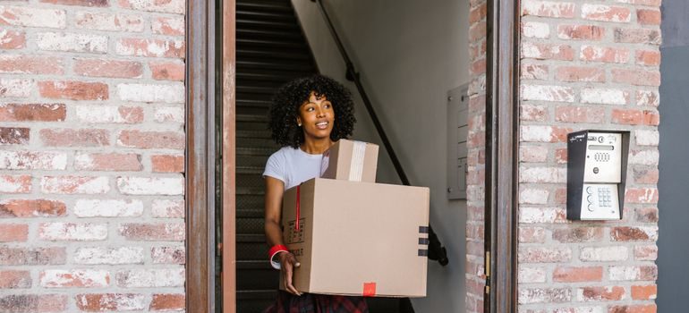 A woman carrying boxes after moving to Greenfield for GCC