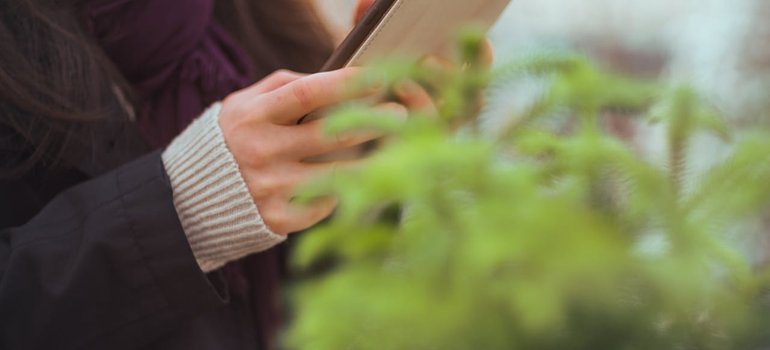A person checking a phone to transfer utilities when moving to a new address