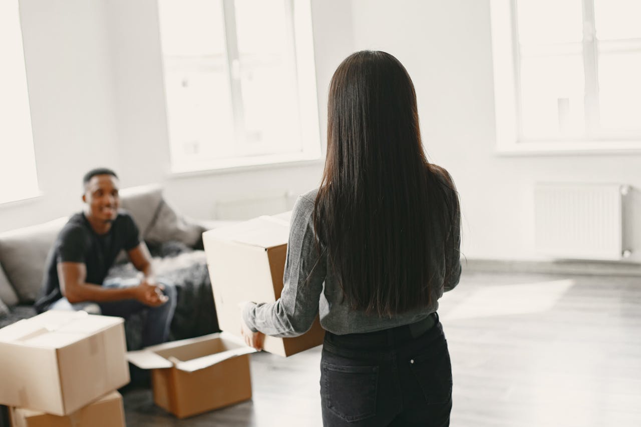 A couple unpacking moving boxes in their new apartment
