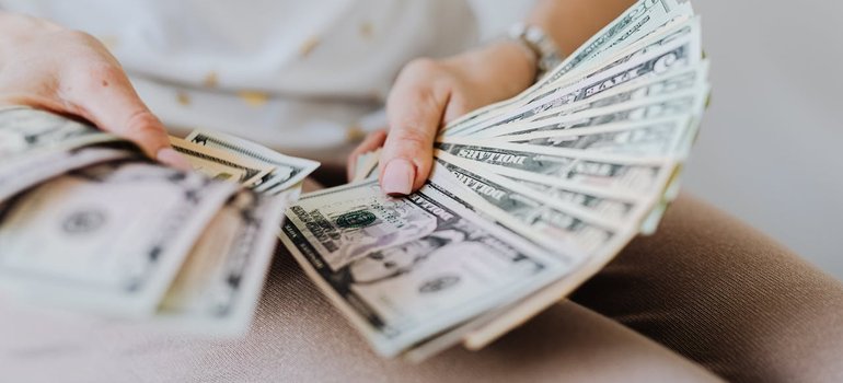 A person fanning out a stack of dollar bills