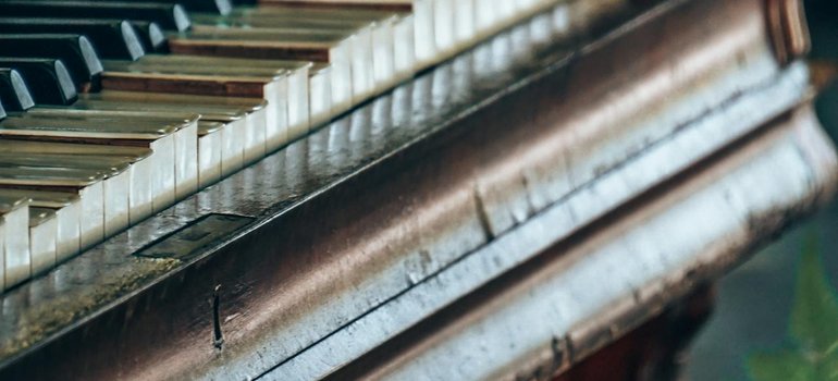 Close-up of an old upright piano keyboard and wooden case