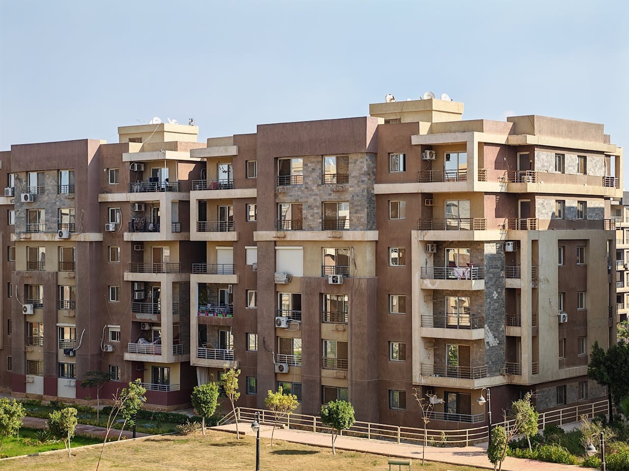 A modern brick apartment building with balconies on a sunny day